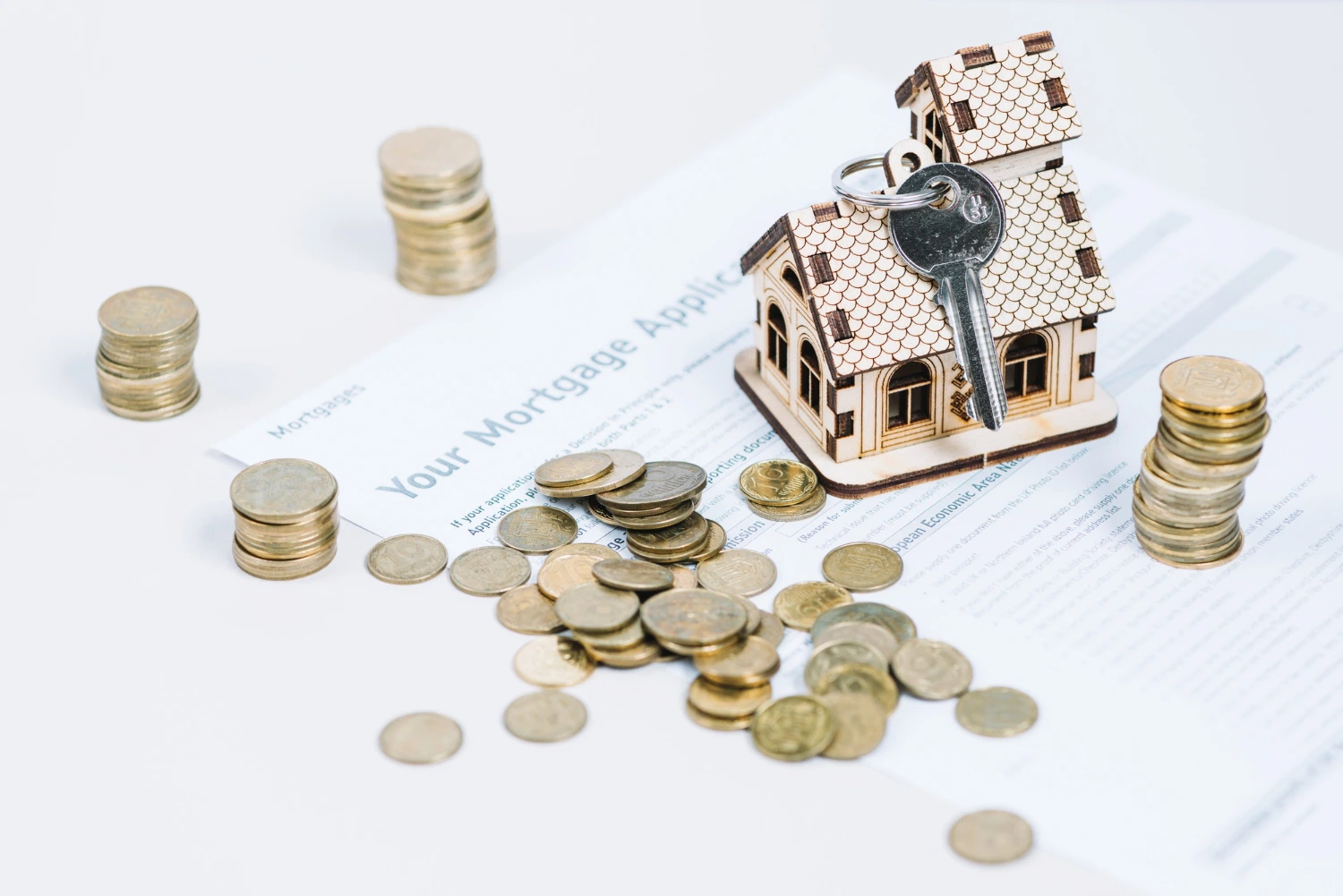 Small house model next to stacks of coins representing housing allowance