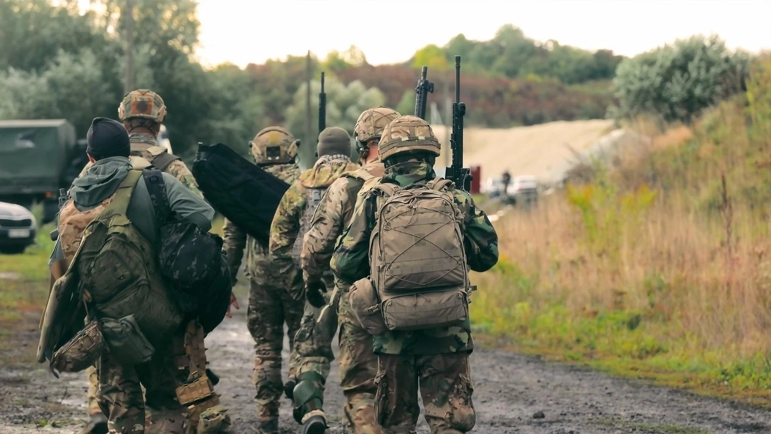 Service members in field uniforms walking together, where rank insignia is worn
