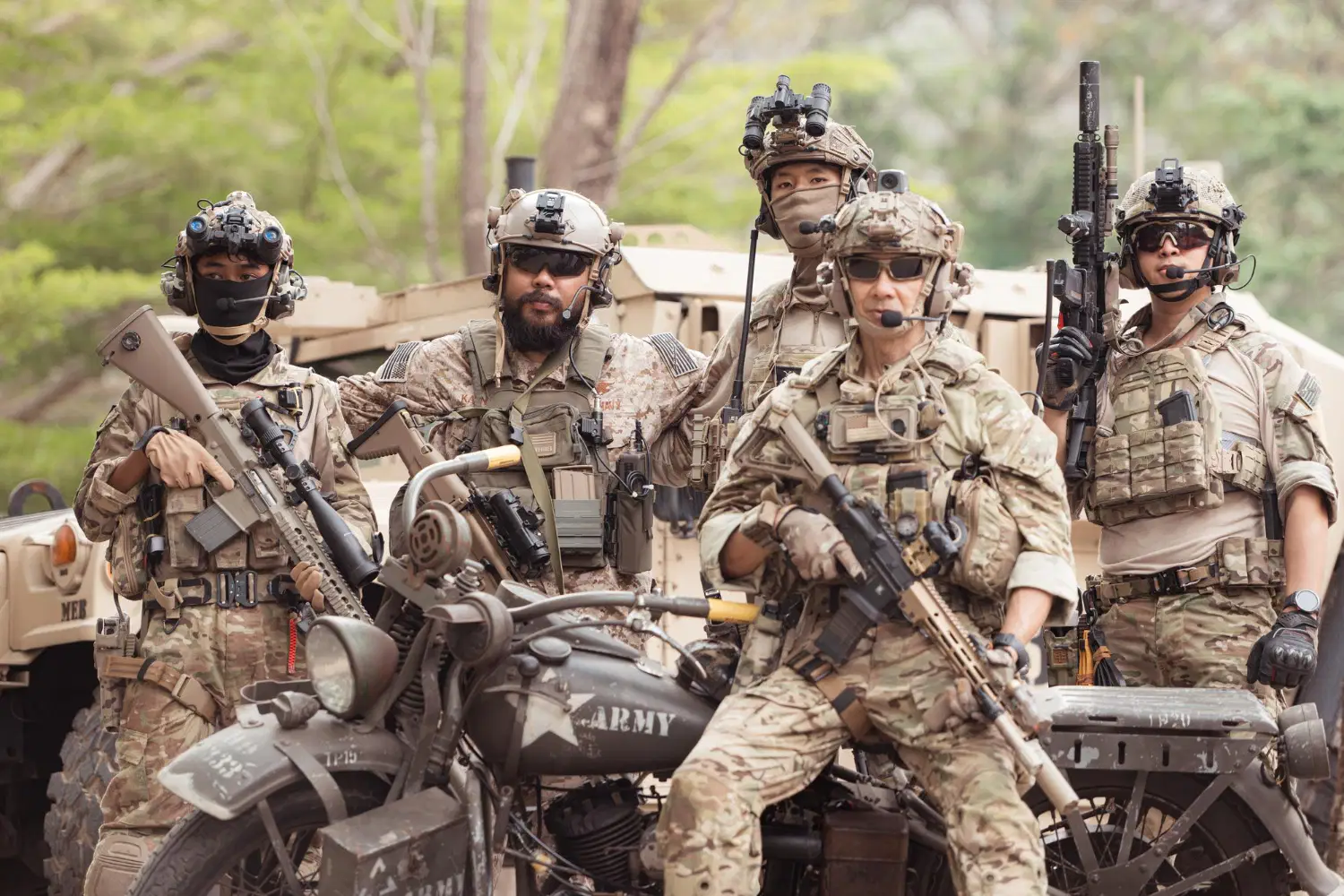 Service members resting with gear in the field, reflecting the new rank names