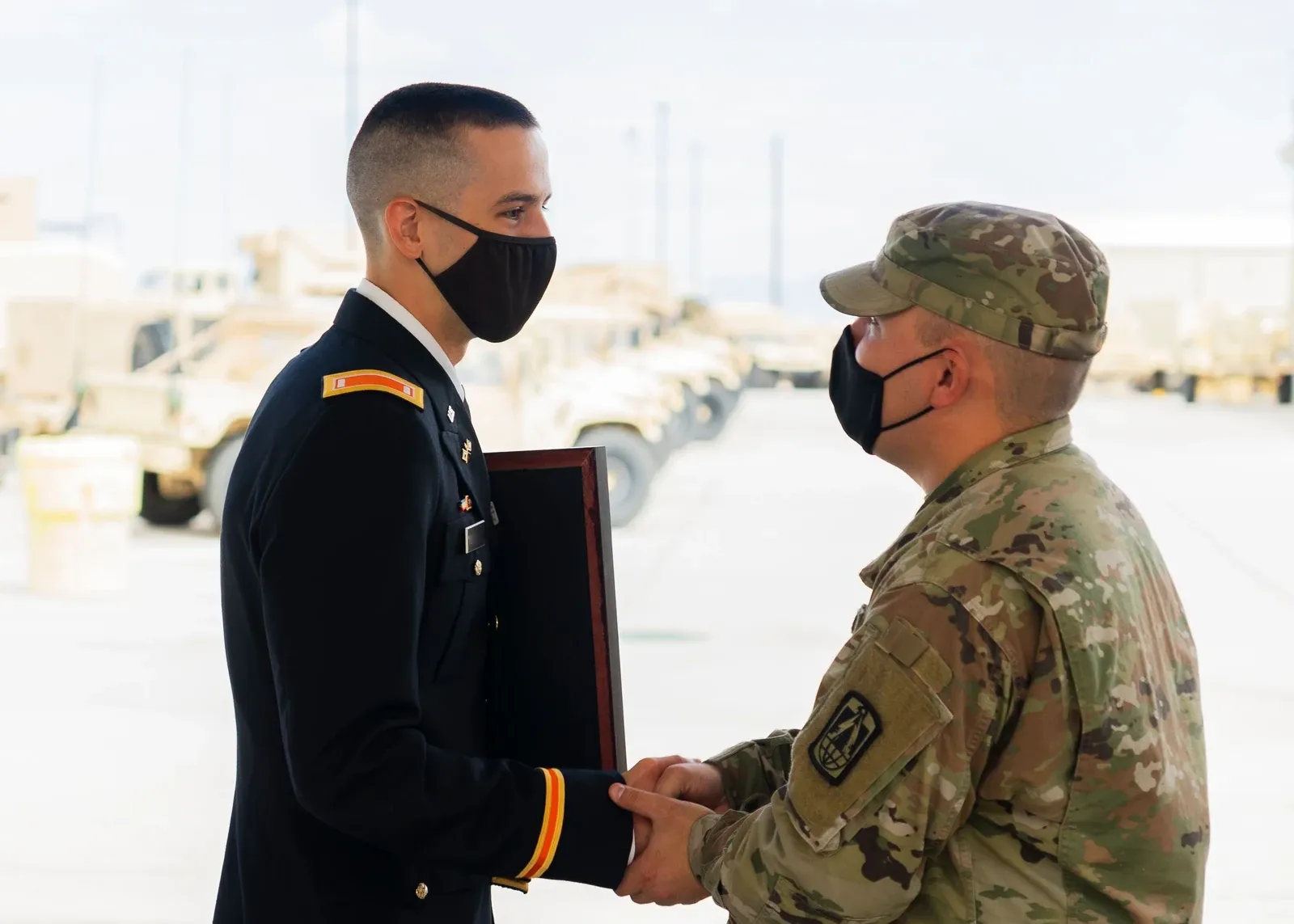 U.S. Army soldier shaking hands with an officer in dress uniform at a ceremony