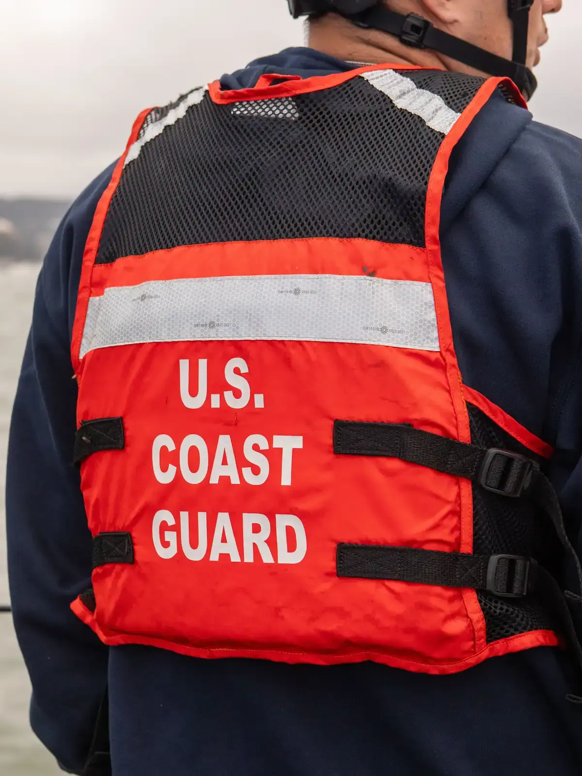 Coast Guard crew member wearing a U.S. Coast Guard flotation vest