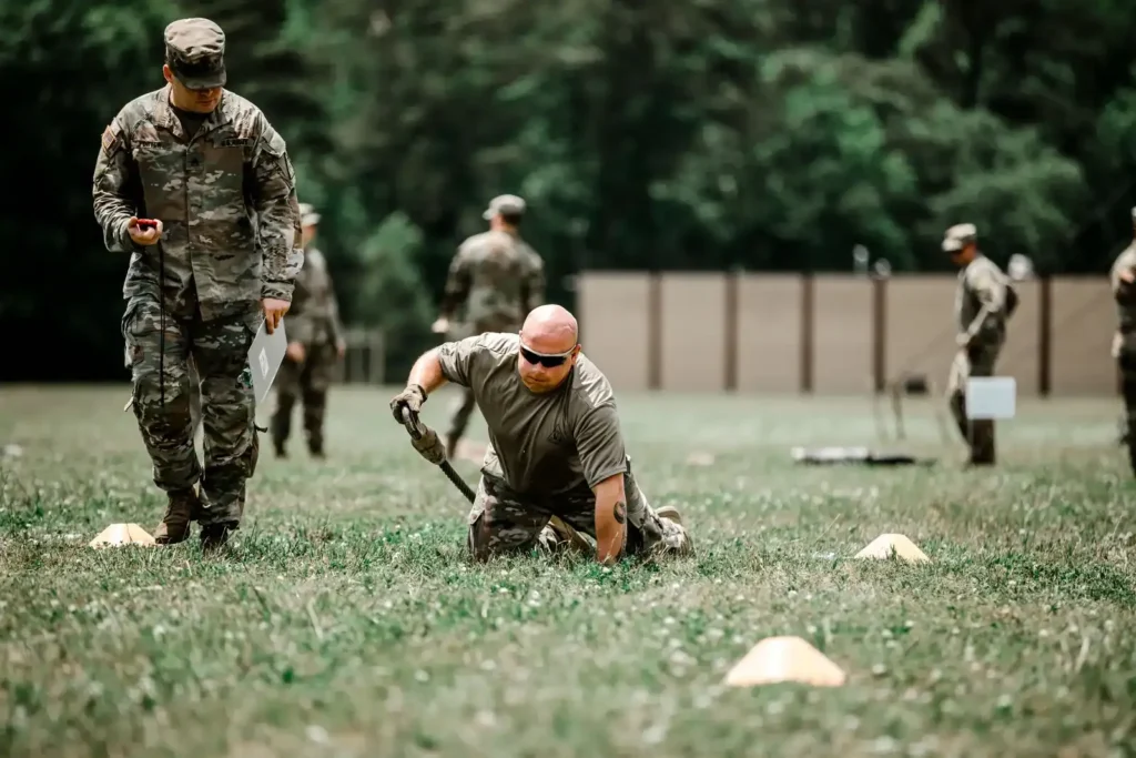 Recruit doing physical training on a field while an instructor watches