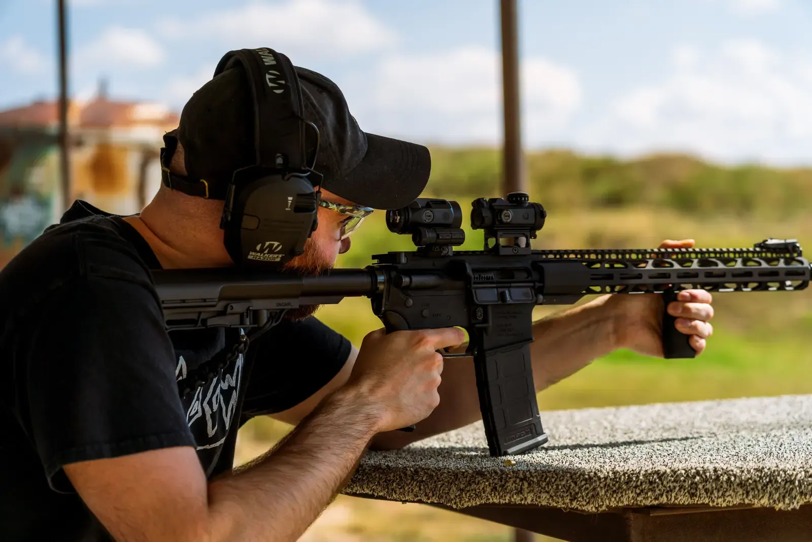 Shooter aiming a rifle at an outdoor shooting range