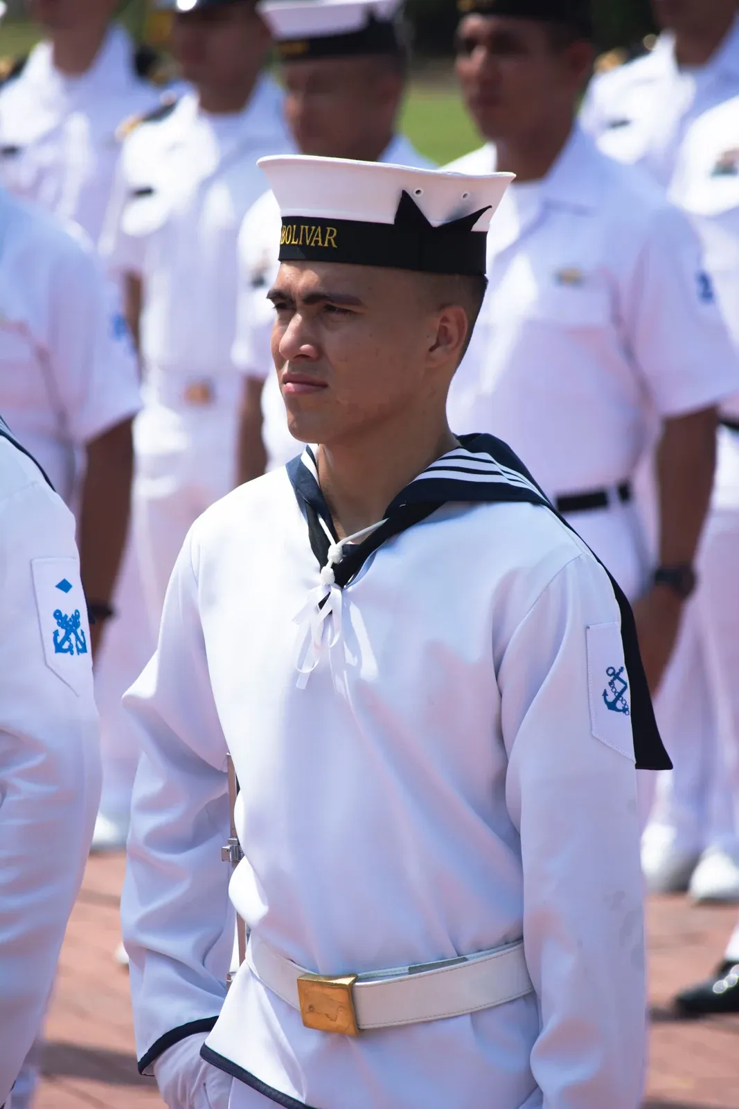 Sailors in white uniforms standing in formation at a ceremony