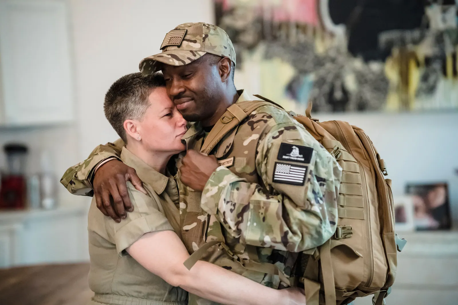 Soldier in uniform hugging a loved one after returning home
