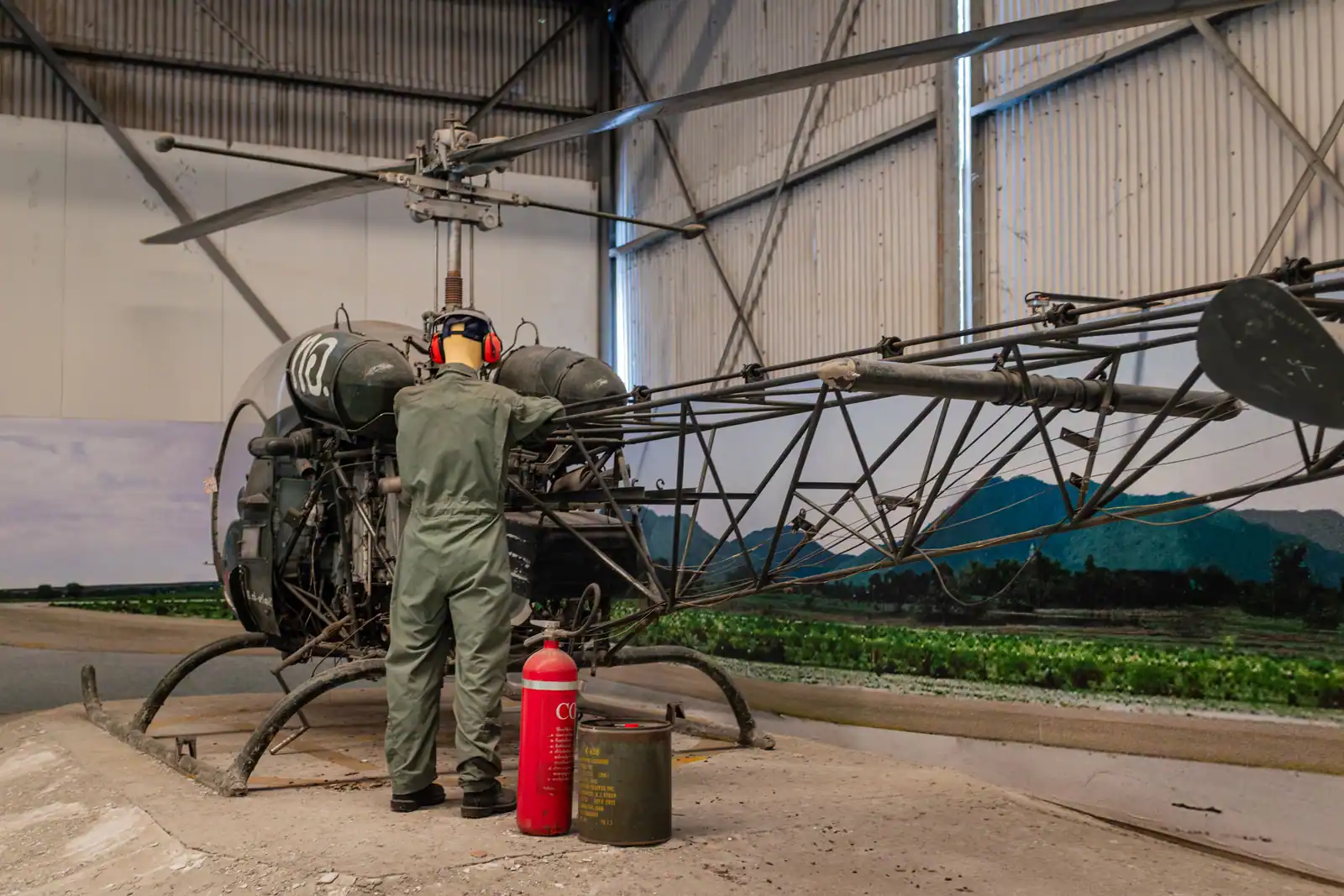 Technician in uniform inspecting a helicopter in a hangar